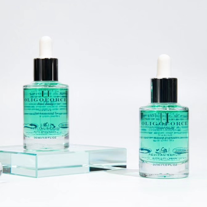 Two bottles of serum sitting on top of a glass block.